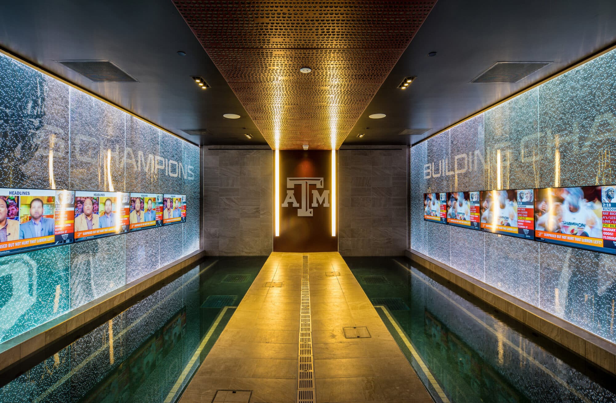 Illuminated collegiate sports hallway with team graphics.