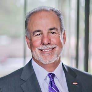 Smiling businessman in suit with tie, professional portrait.