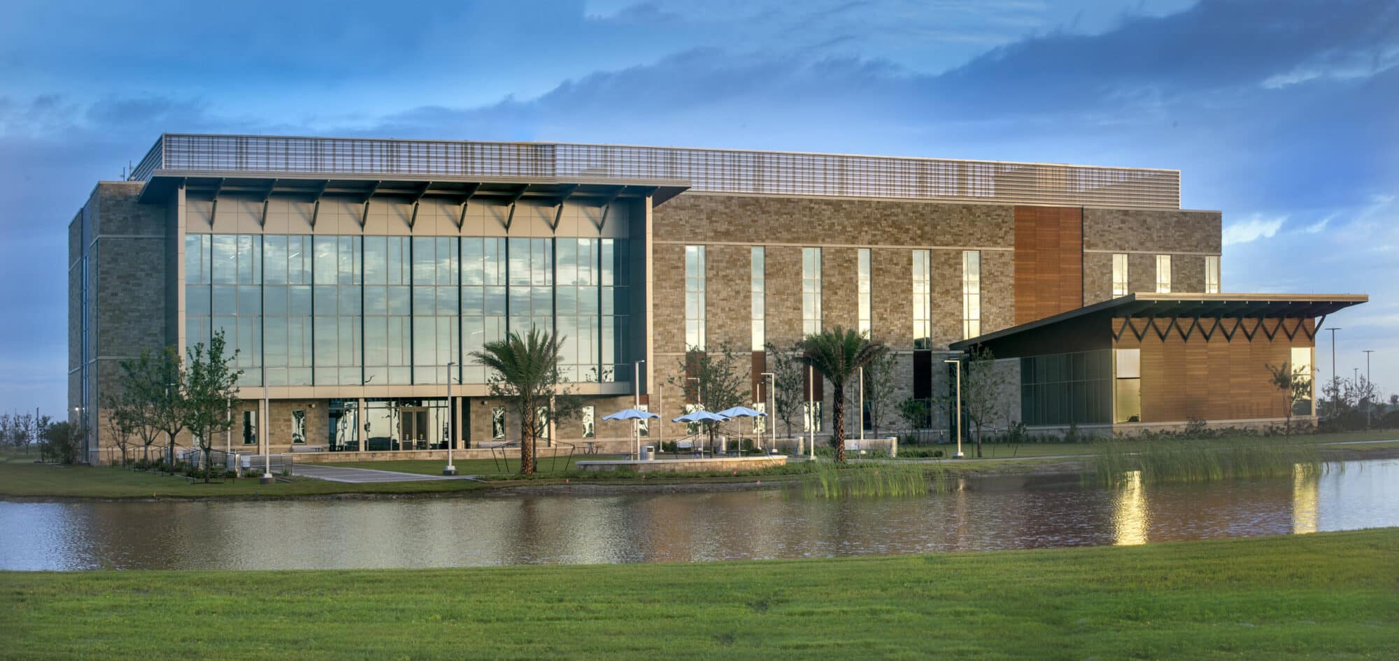 Modern office building near water at dusk.