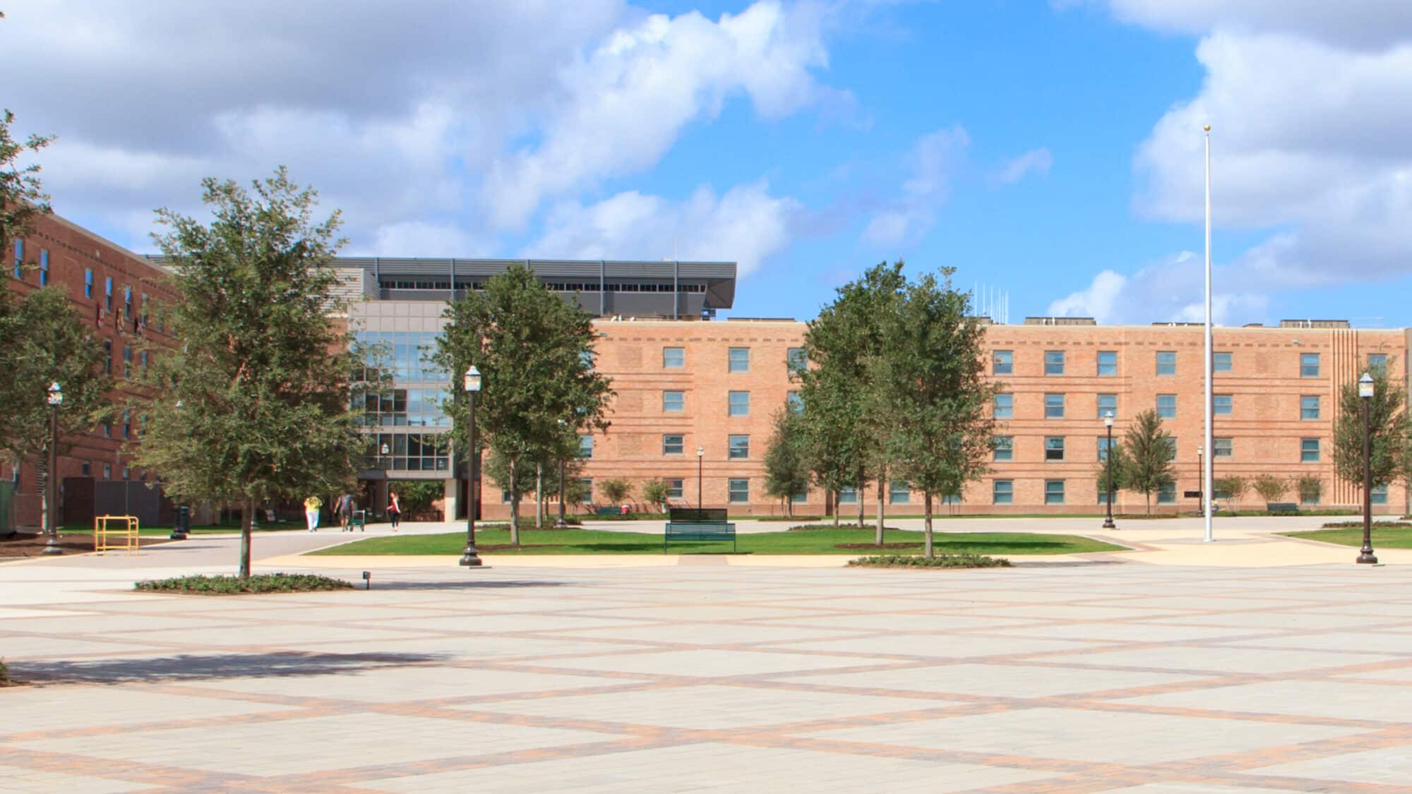 Campus plaza with brick buildings and trees.