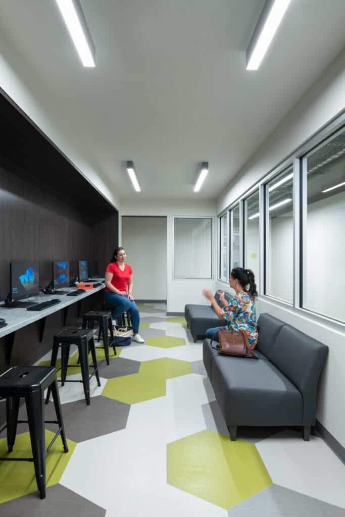 Modern office lounge with two people chatting.