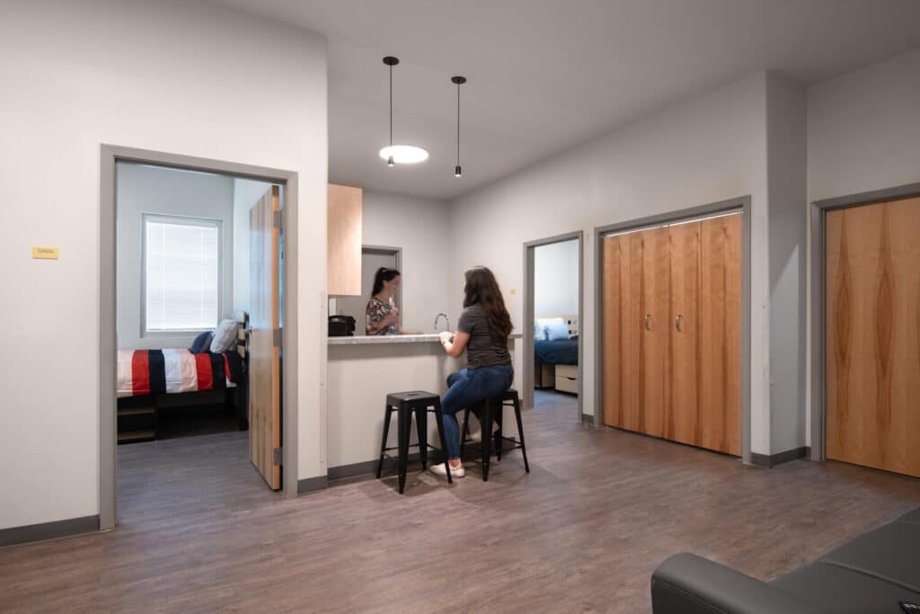 Modern dormitory room with two people chatting.