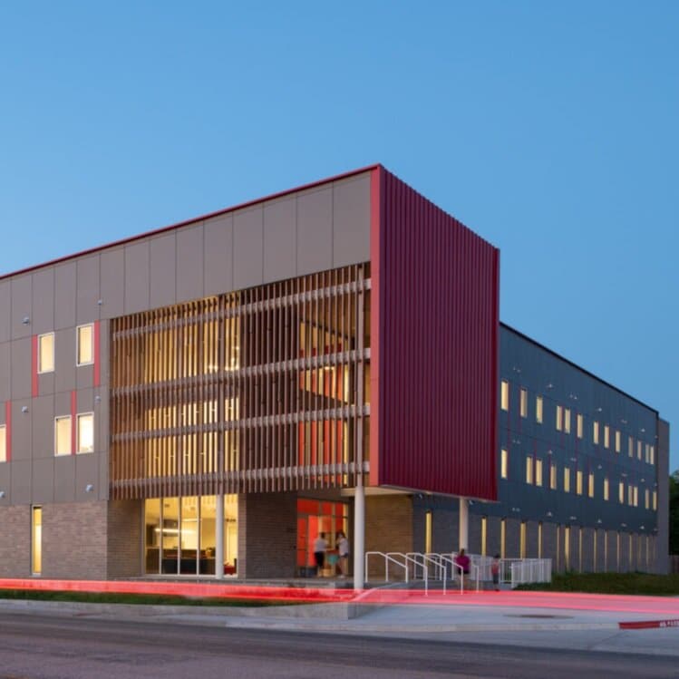 Modern building exterior at dusk with lighting.