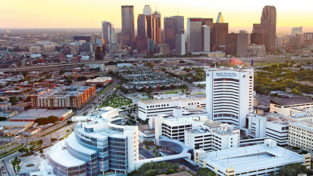 Aerial view of downtown Dallas skyline at sunset.