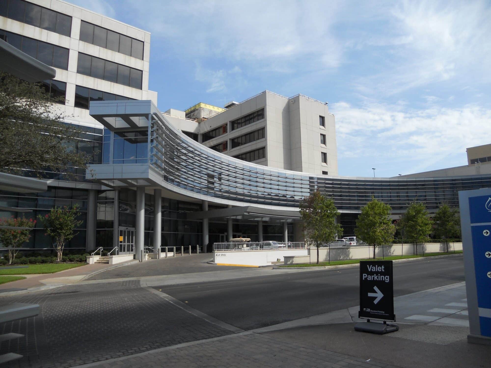 Modern hospital building with valet parking sign.