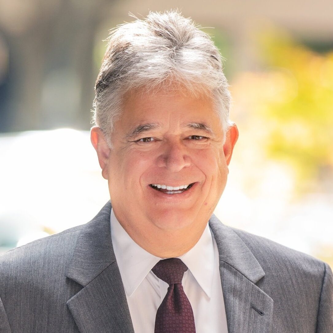 Smiling businessman in suit outdoors.