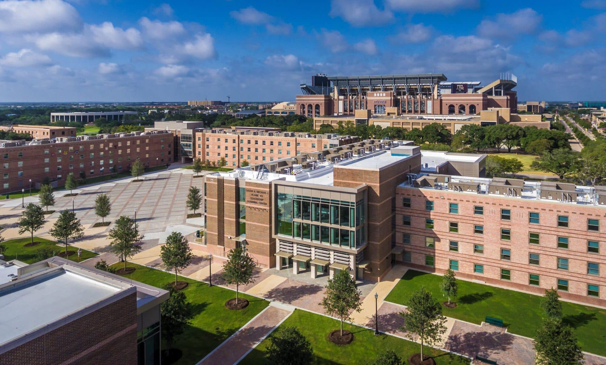 University campus aerial view with stadium in background.