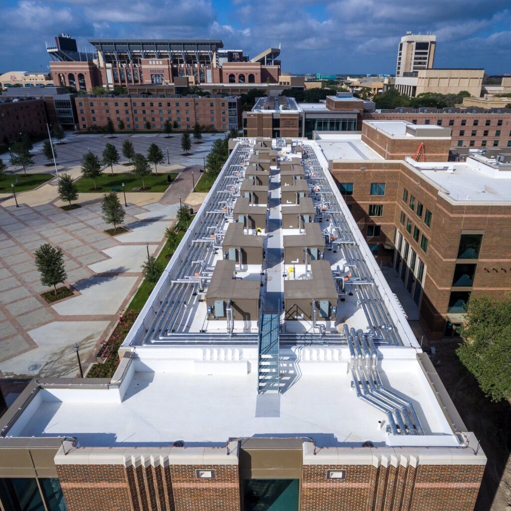 Aerial view of university campus buildings with rooftop equipment.