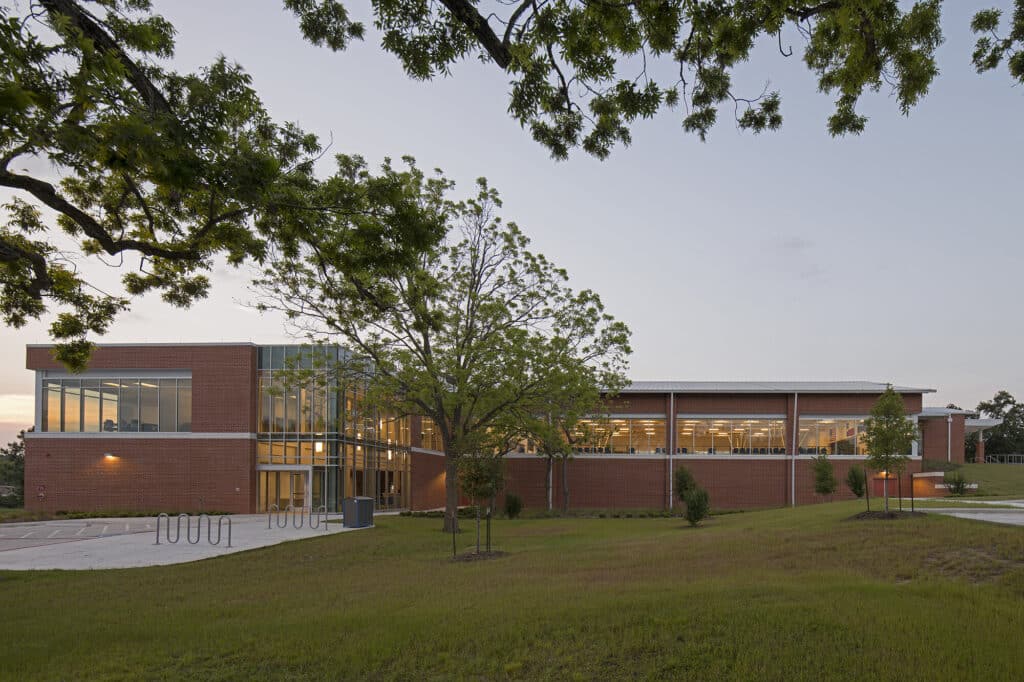 Modern brick building with illuminated windows at twilight.