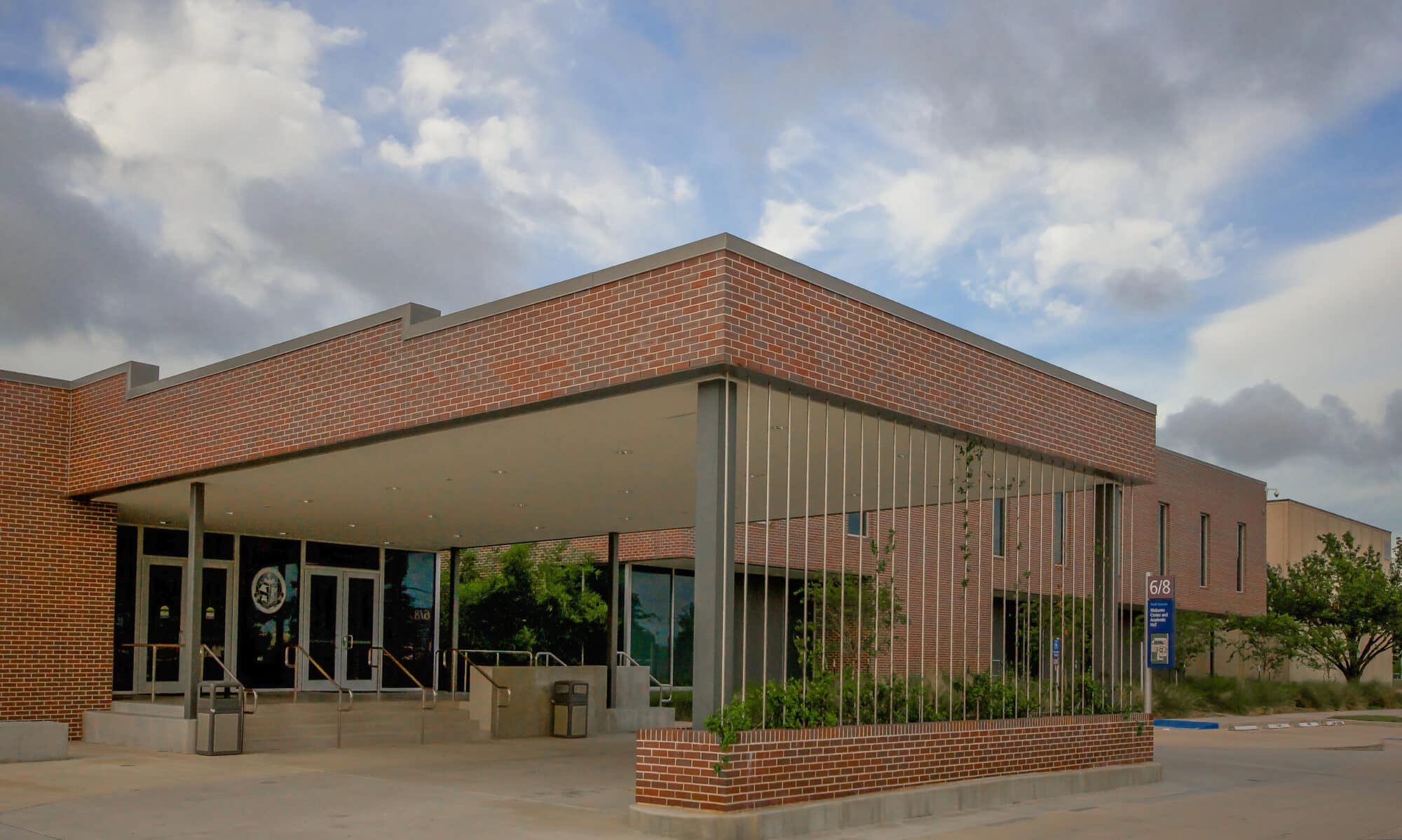 Modern brick building entrance with overcast sky.