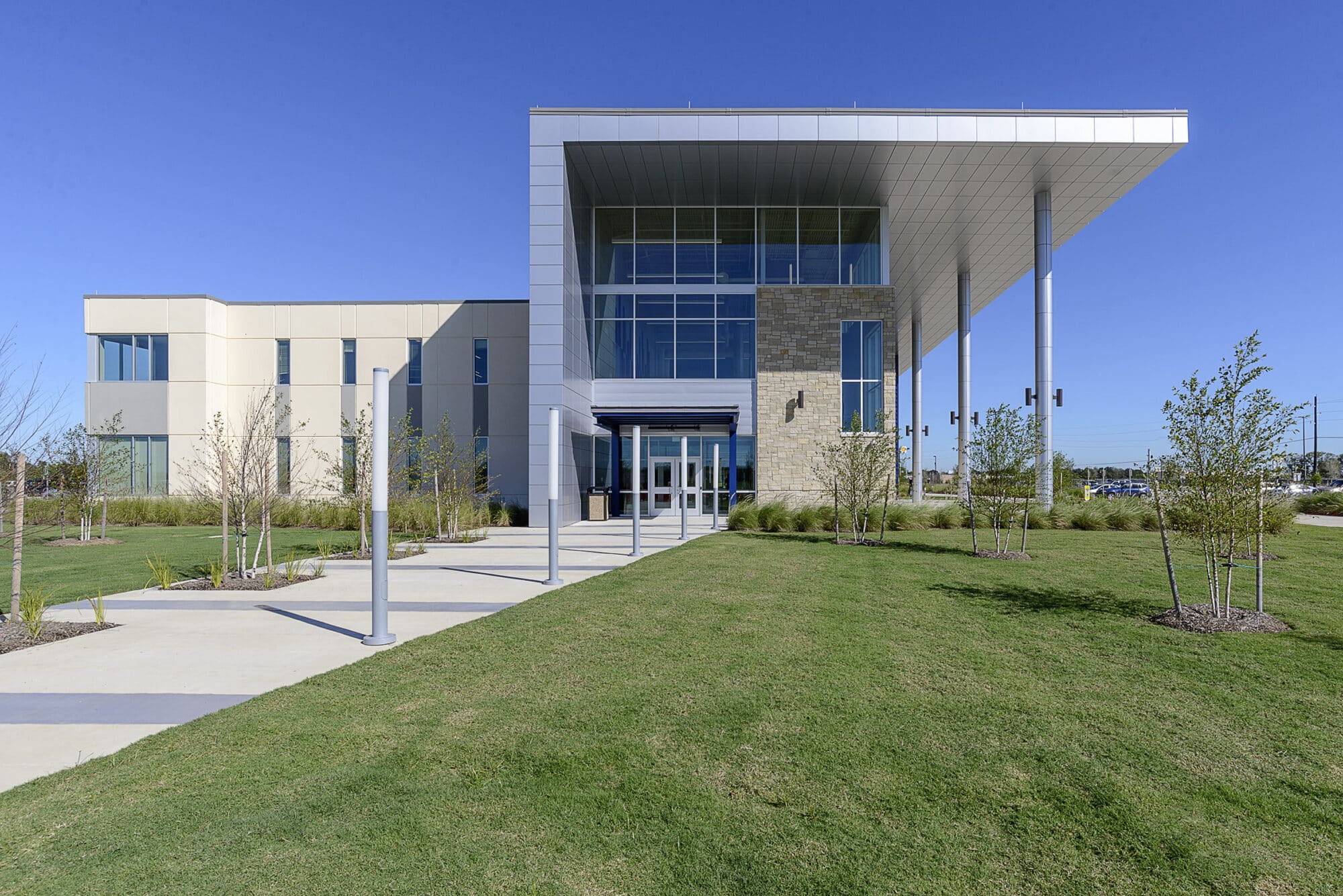 Modern office building entrance with landscaped pathway.