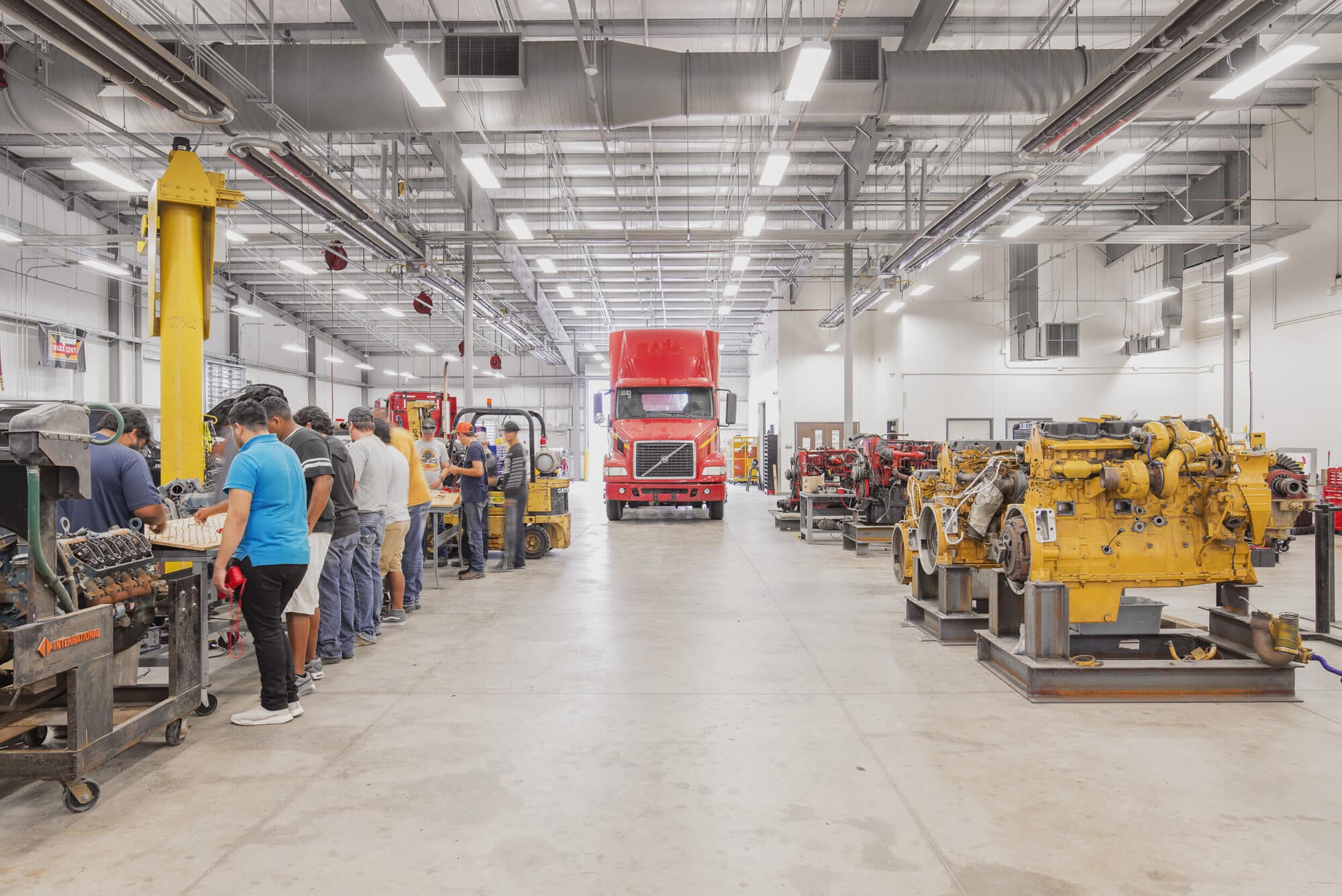 Workers in busy truck repair facility.