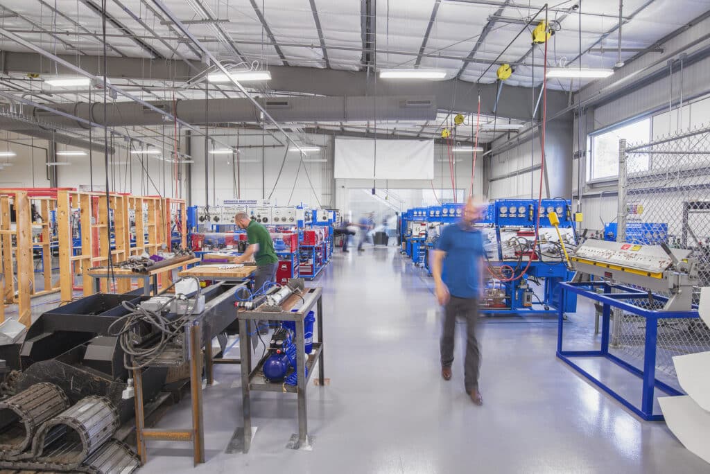 Workers in industrial manufacturing facility with machinery.