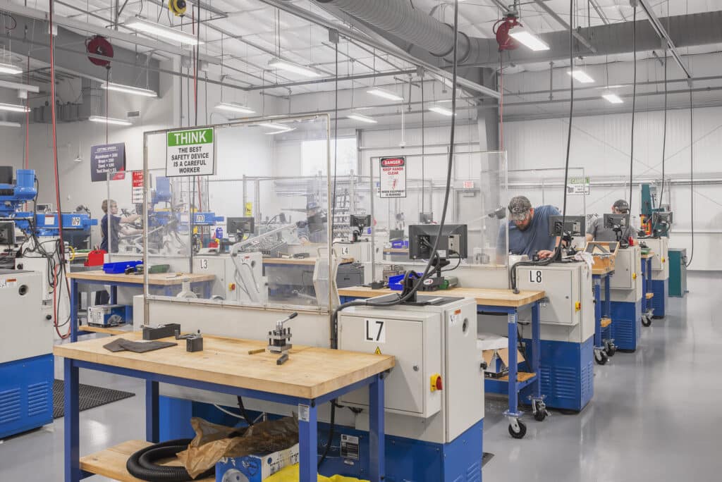 Workers operating machinery in industrial workshop.