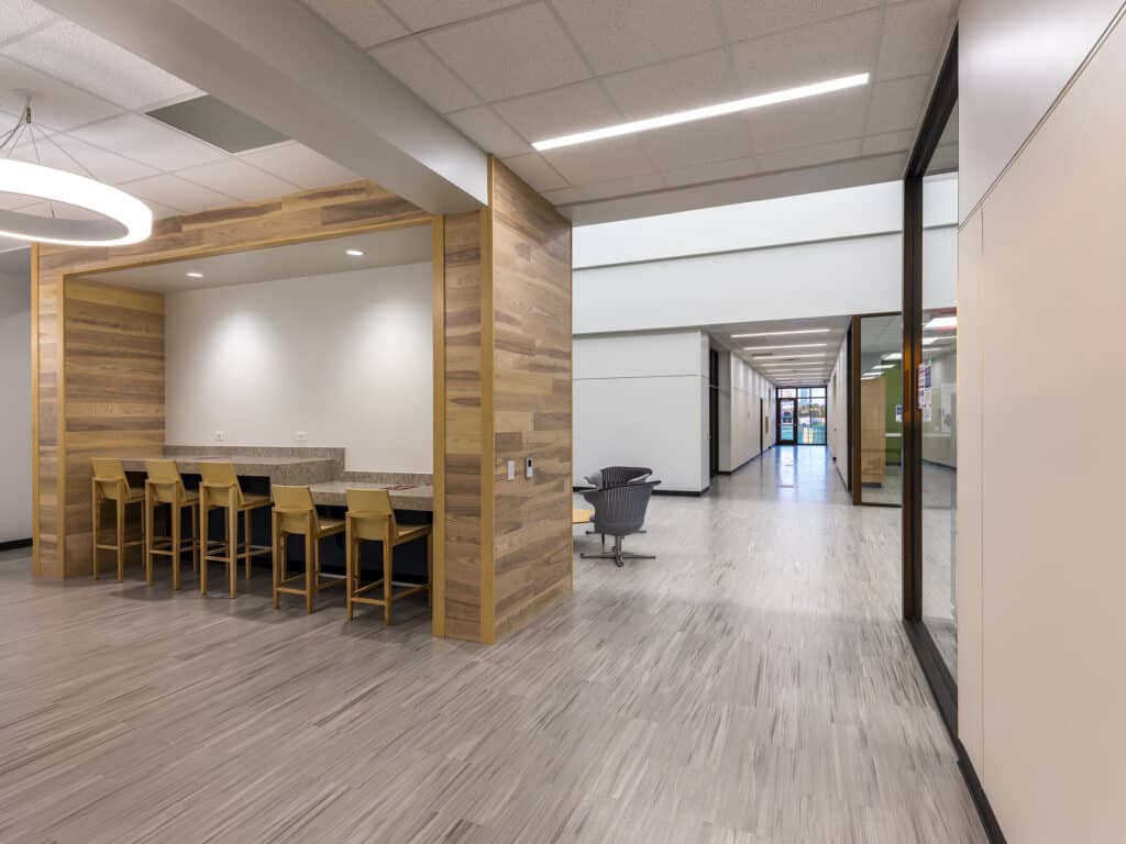Modern office break room and corridor with wooden accents.