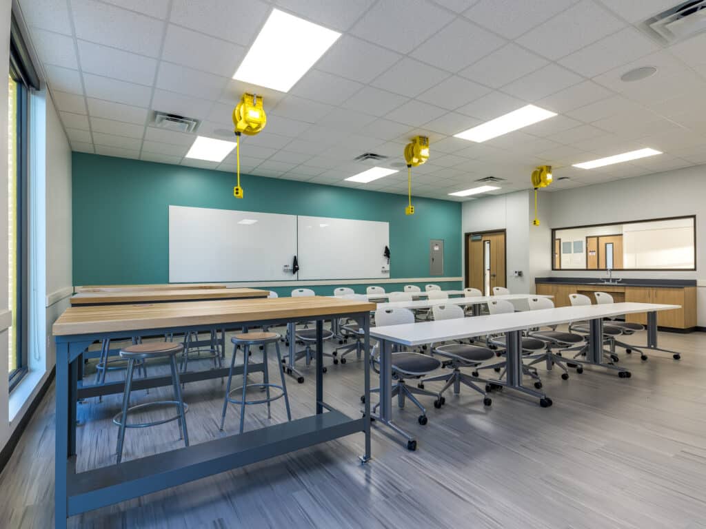 Modern classroom interior with tables and whiteboard.