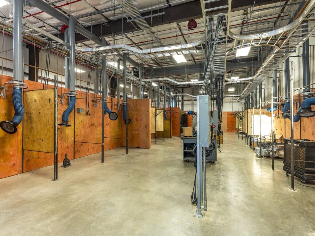 Industrial workshop with machinery and ventilation ducts.