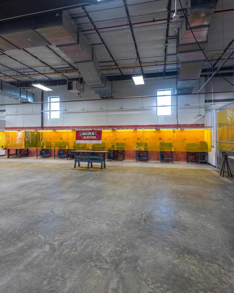 Industrial welding workshop interior with safety booths.