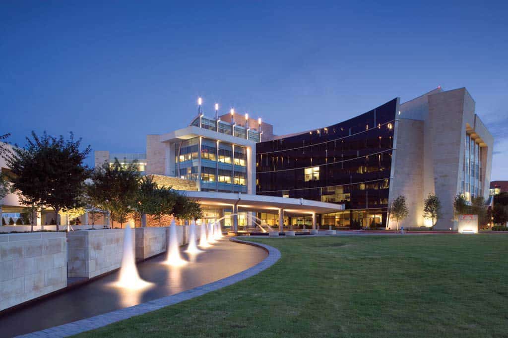 Modern building exterior at dusk with illuminated pathway.