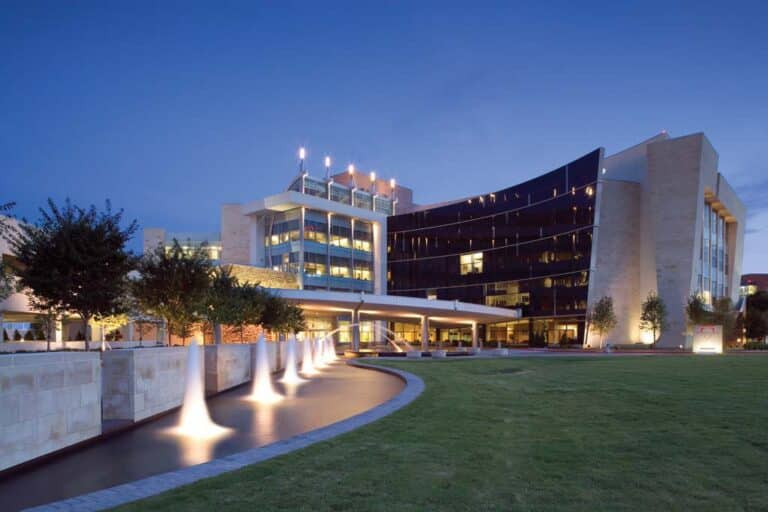 Modern office building at twilight with outdoor lighting.