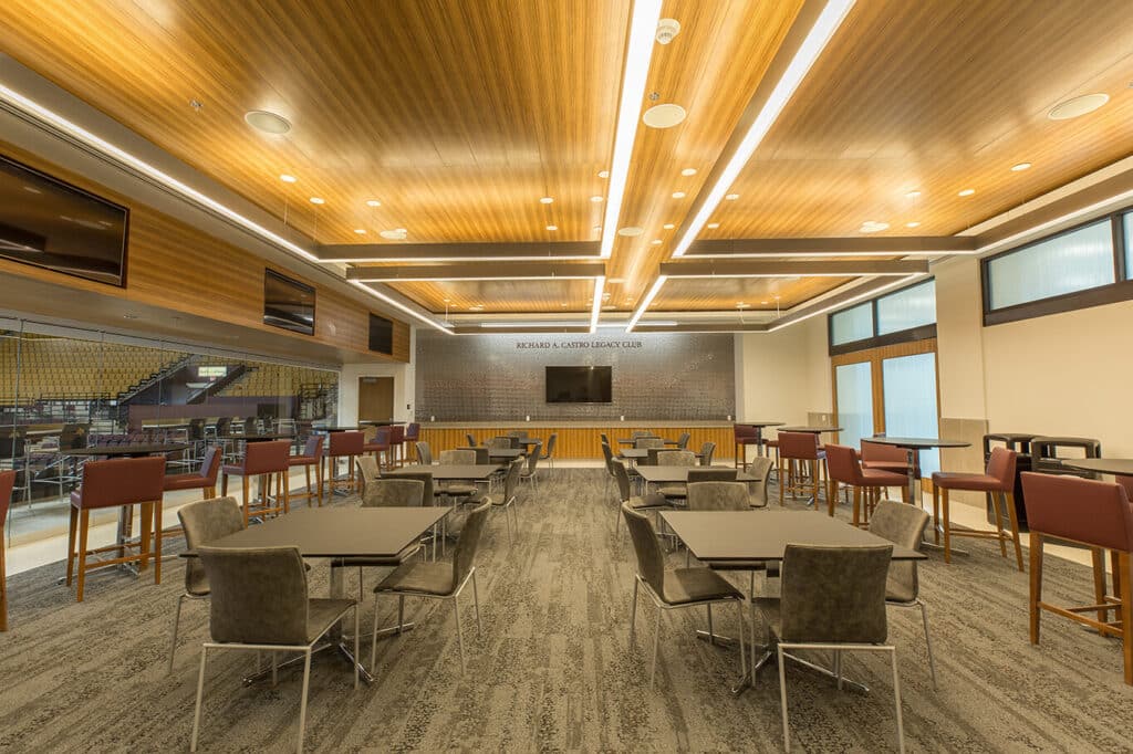 Modern dining hall with wooden ceiling and tables.