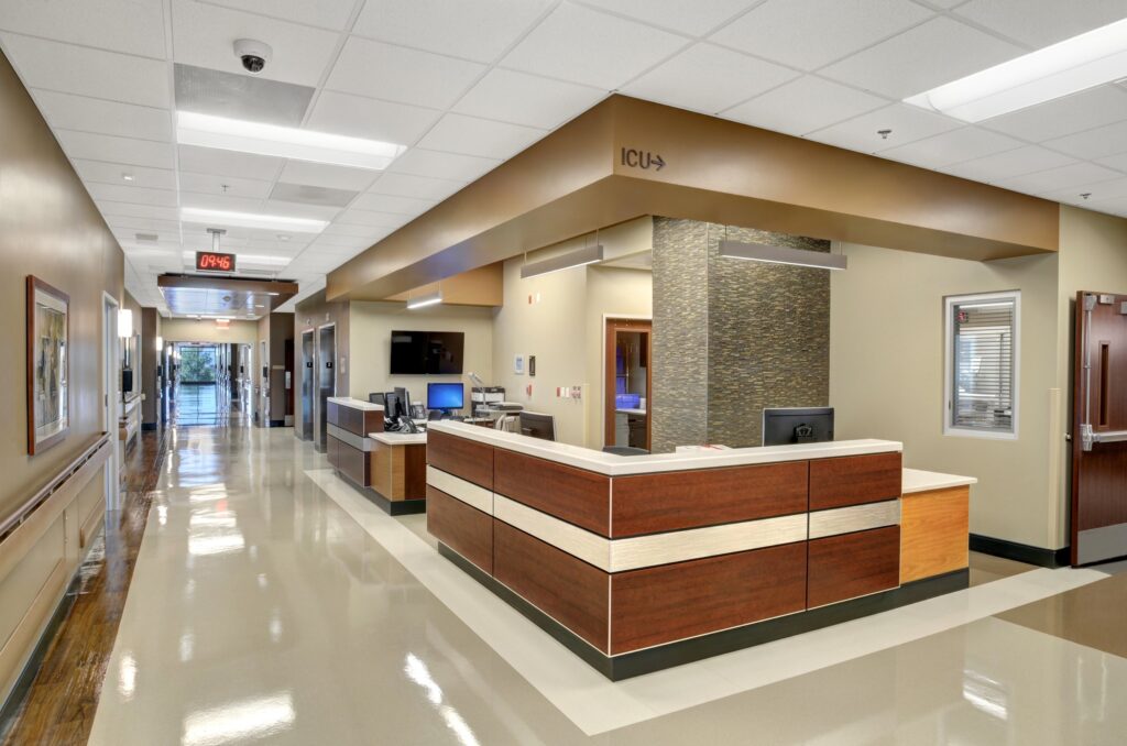 Modern hospital corridor with reception desk.