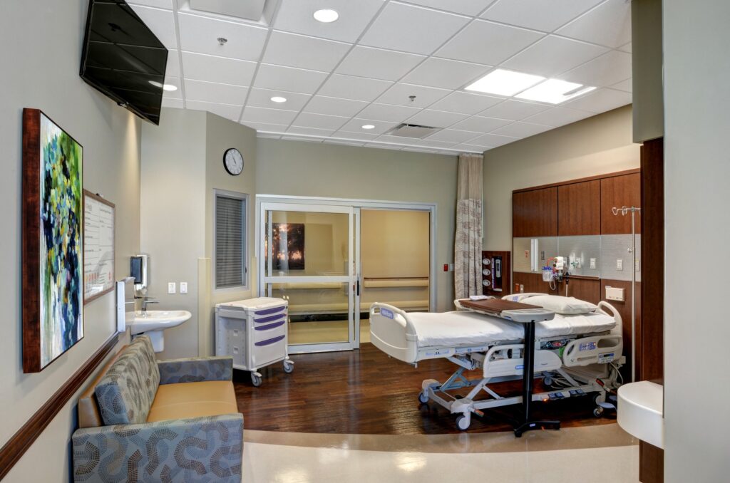 Modern hospital room with medical equipment and furniture.