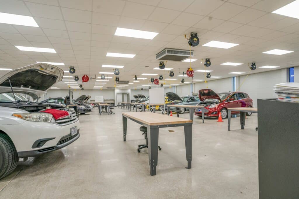 Auto repair shop interior with vehicles and equipment.