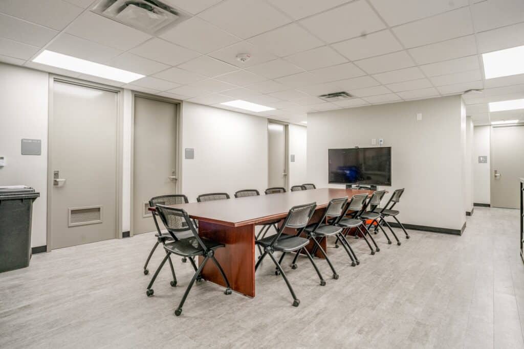 Modern conference room with large table and chairs.