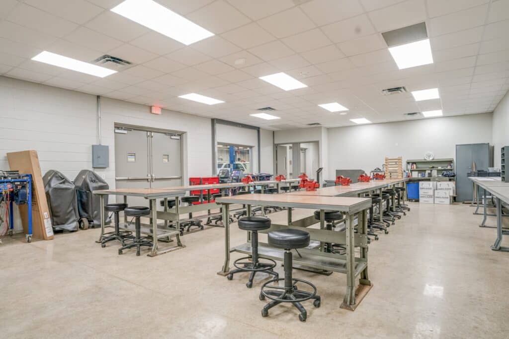 Spacious industrial workshop with tables and stools.