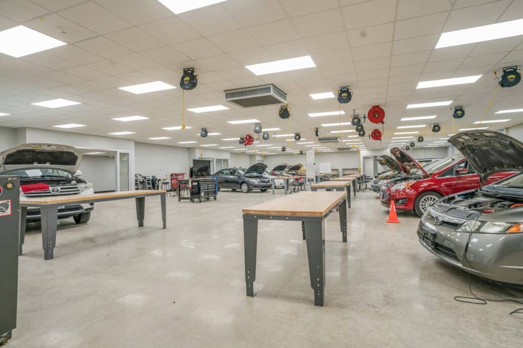 Modern car repair workshop interior with vehicles.