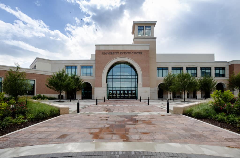 Modern University Events Center facade with clear sky.