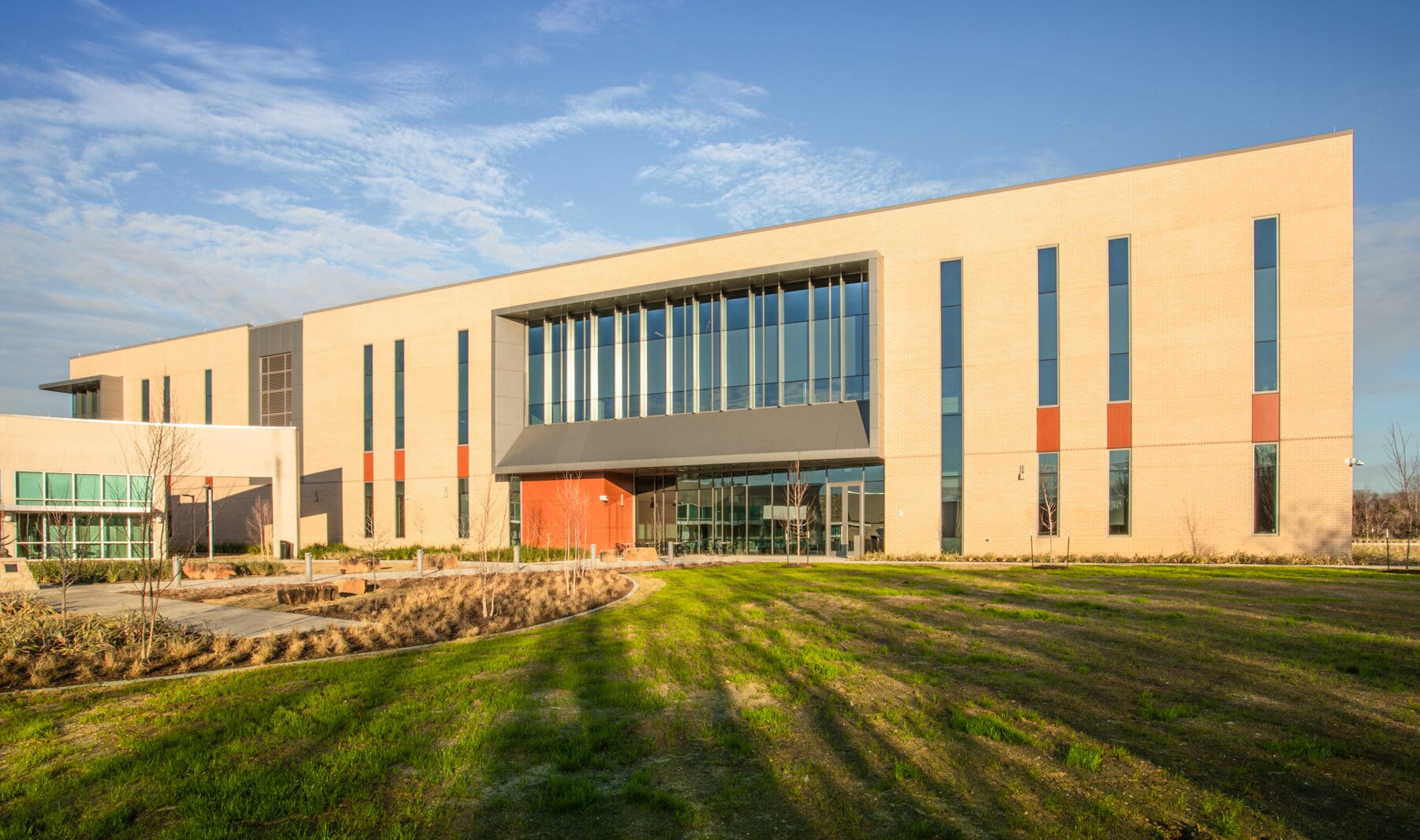 Modern building exterior with large windows and landscaped grounds.