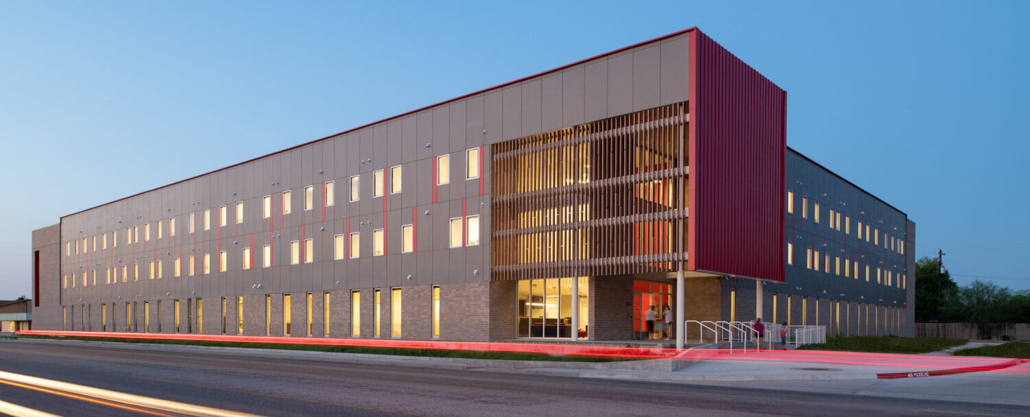 Modern commercial building at dusk with lights on.