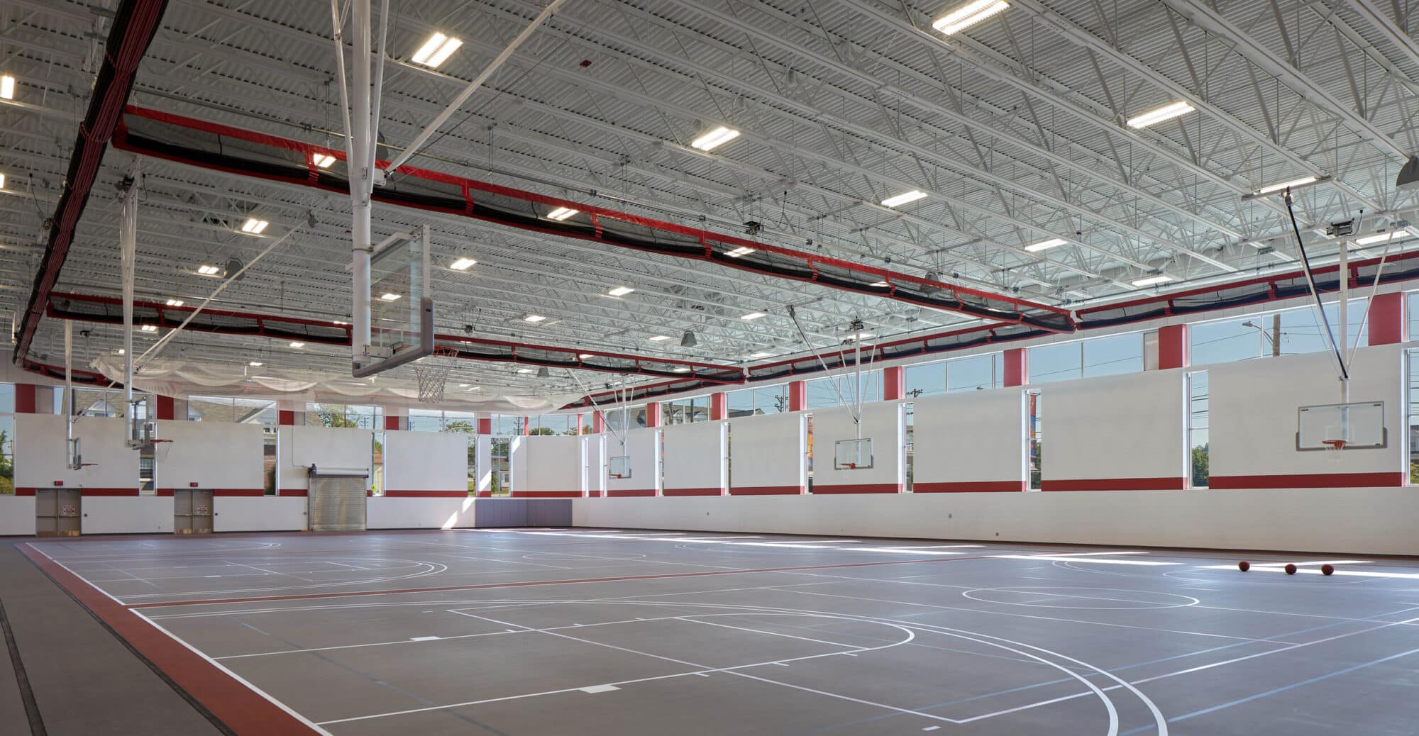 Indoor basketball court with multiple hoops and markings.