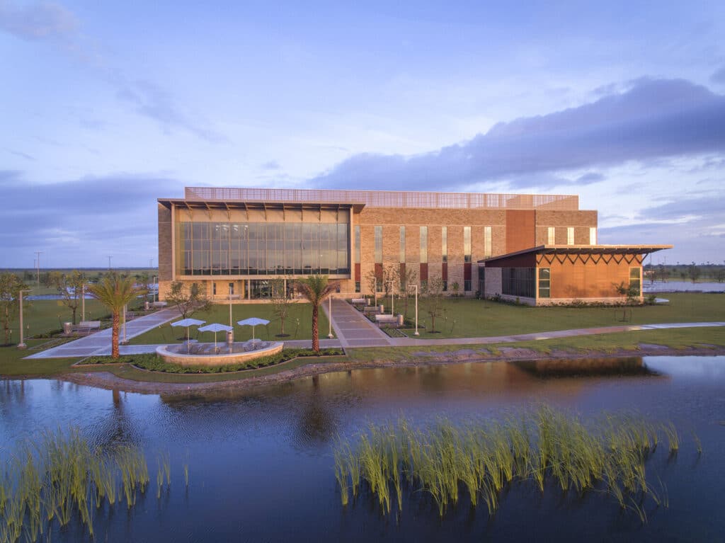 Modern building beside tranquil pond at dusk