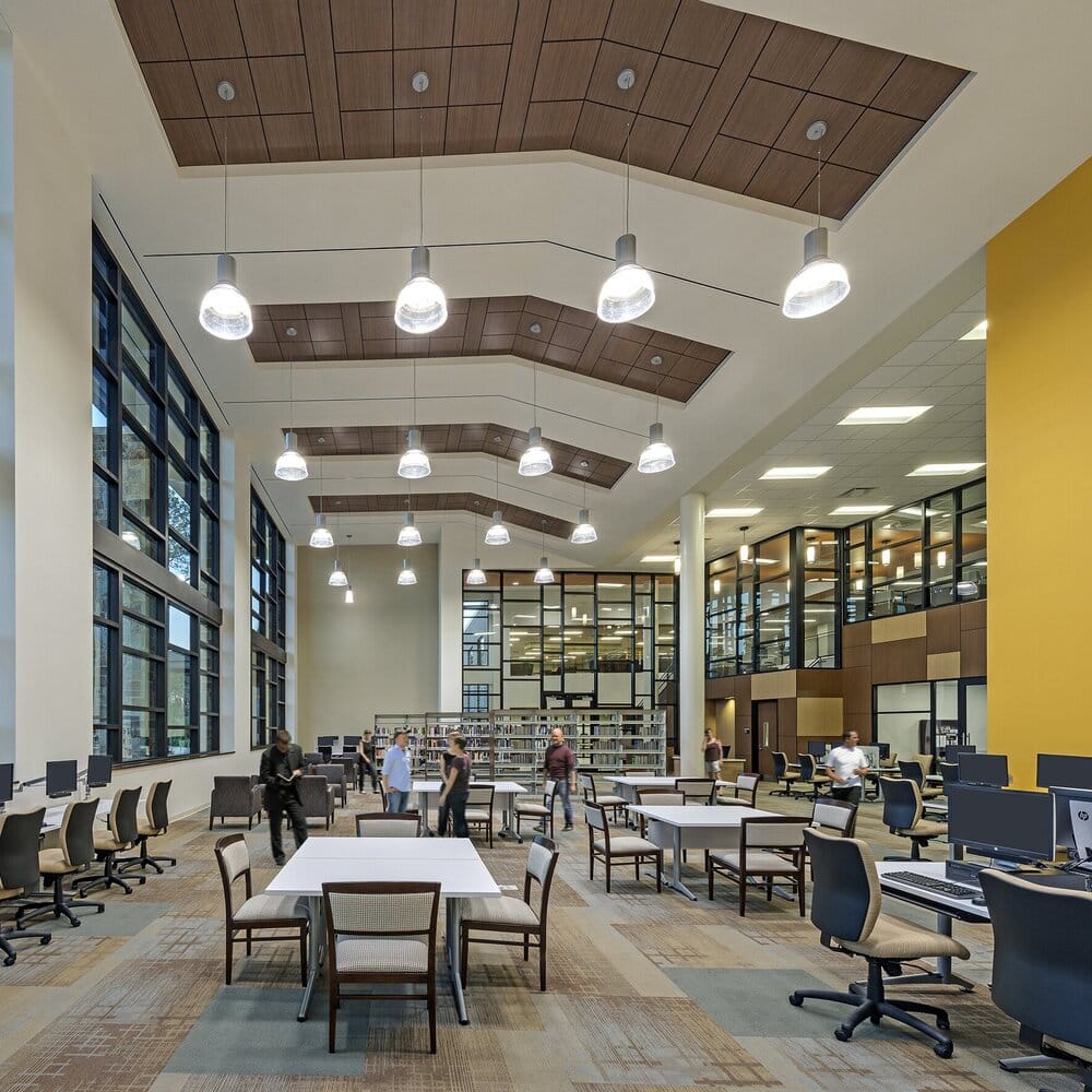 Modern library interior with students and computers.