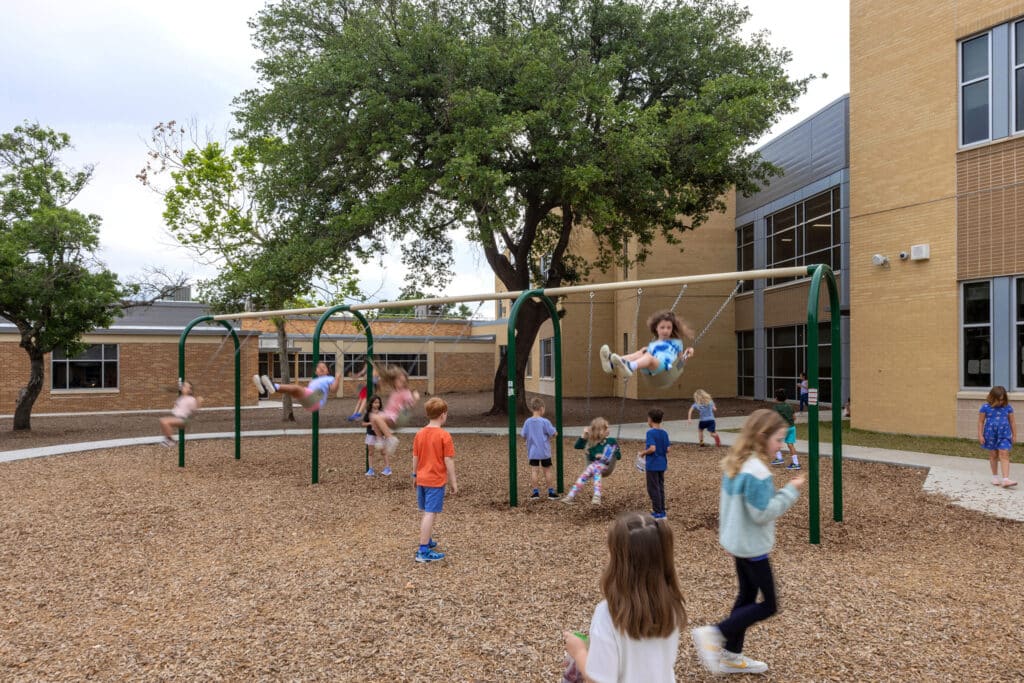 Children playing on school playground swings