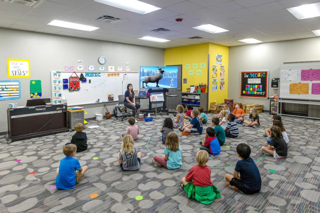 Teacher leading music class for elementary students.