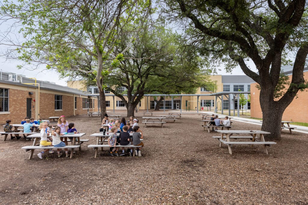 Children at outdoor school picnic tables.