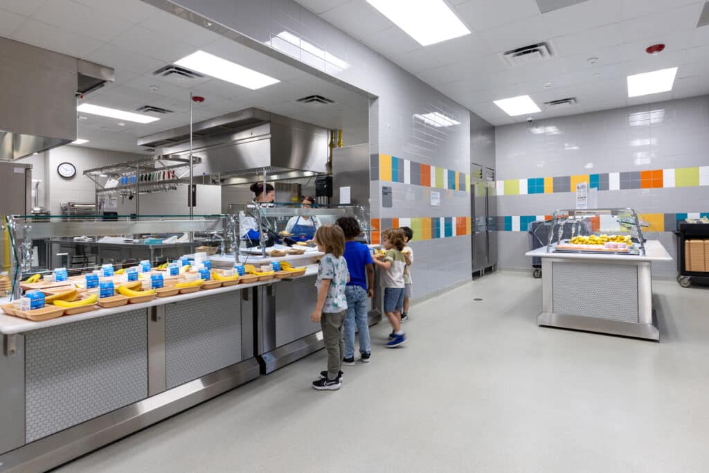 Children lining up in school cafeteria.