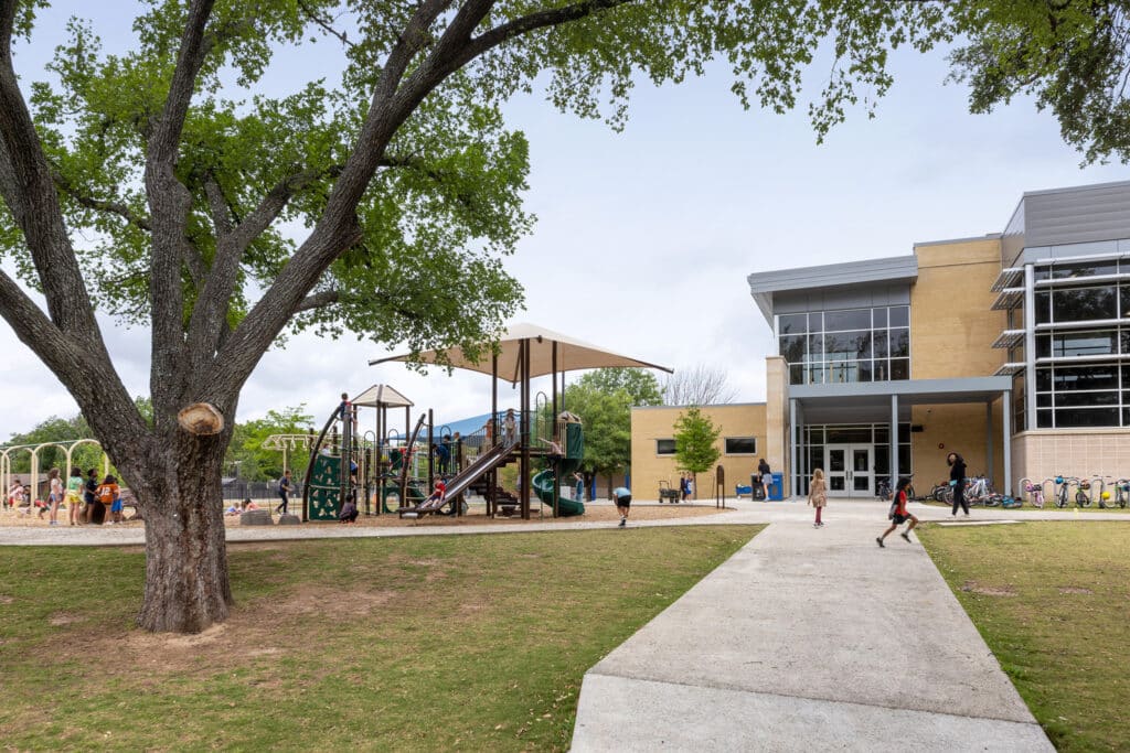 Elementary school playground with children and building.