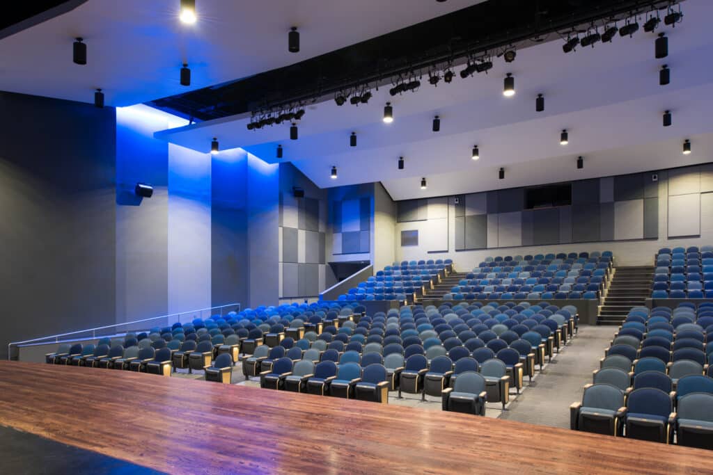 Modern auditorium with blue seats and stage lighting
