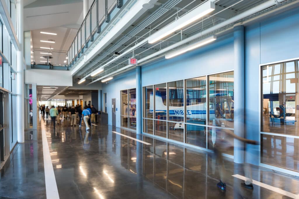 Modern airport terminal interior with passengers and helicopter.