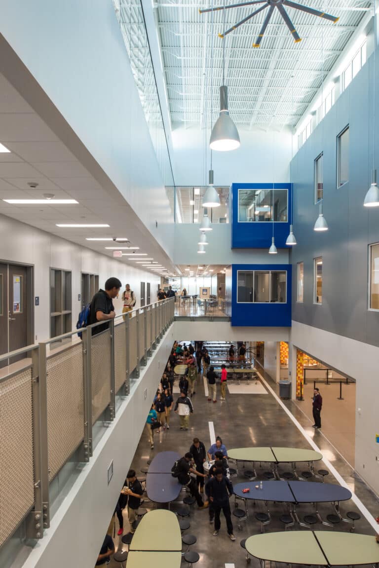 Modern school atrium with students and staff.